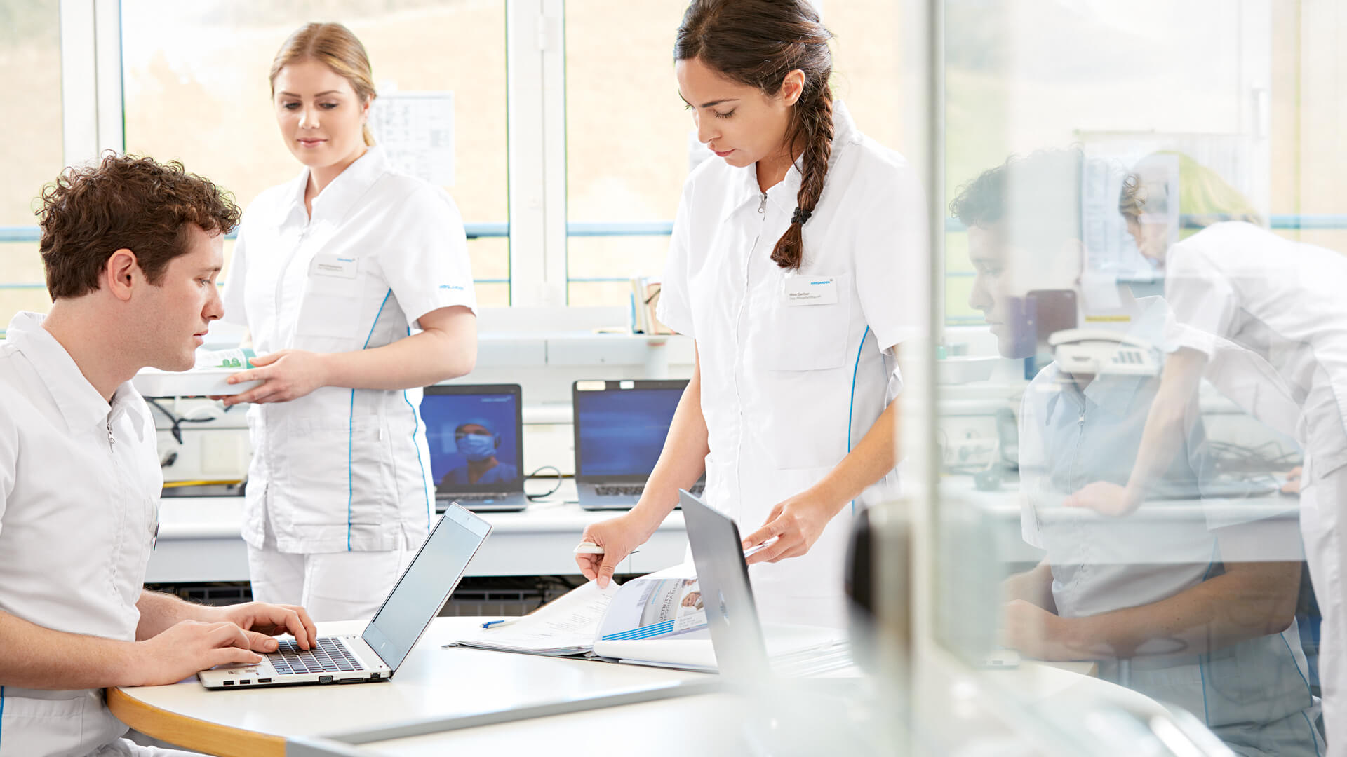 Pflege unterhalten sich über eine Patientendokumentation im Stationszimmer